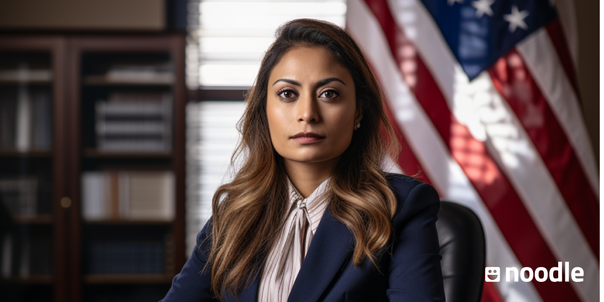 A woman lawyer sits in front of a U.S. flag. 